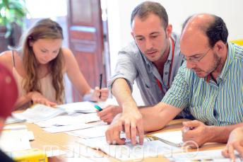 Učiteľ angličtiny vysvetľuje niečo žiakovi v triede