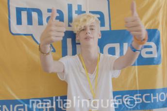 Študent letnej školy zdvihá palec nahor