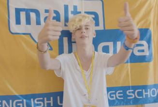 Študent letnej školy zdvihá palec nahor